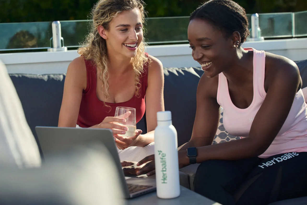 Two colleagues looking at a laptop together during a busy day